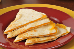 A warm, grilled flour tortilla filled with melted cheese